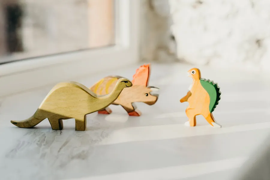 A windowsill of well-loved wooden toys in morning light
